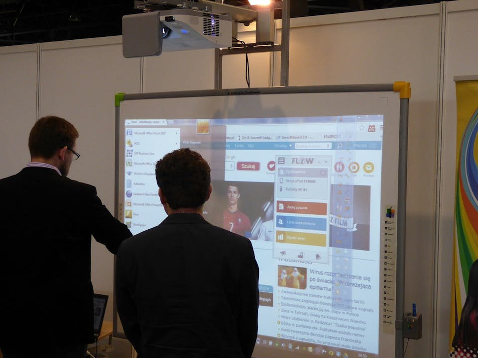 Man viewing interactive whiteboard at trade show exhibit.